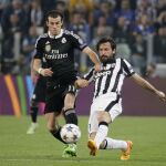 Pirlo araña un balón a Bale durante la semifinal de ayer en Turín