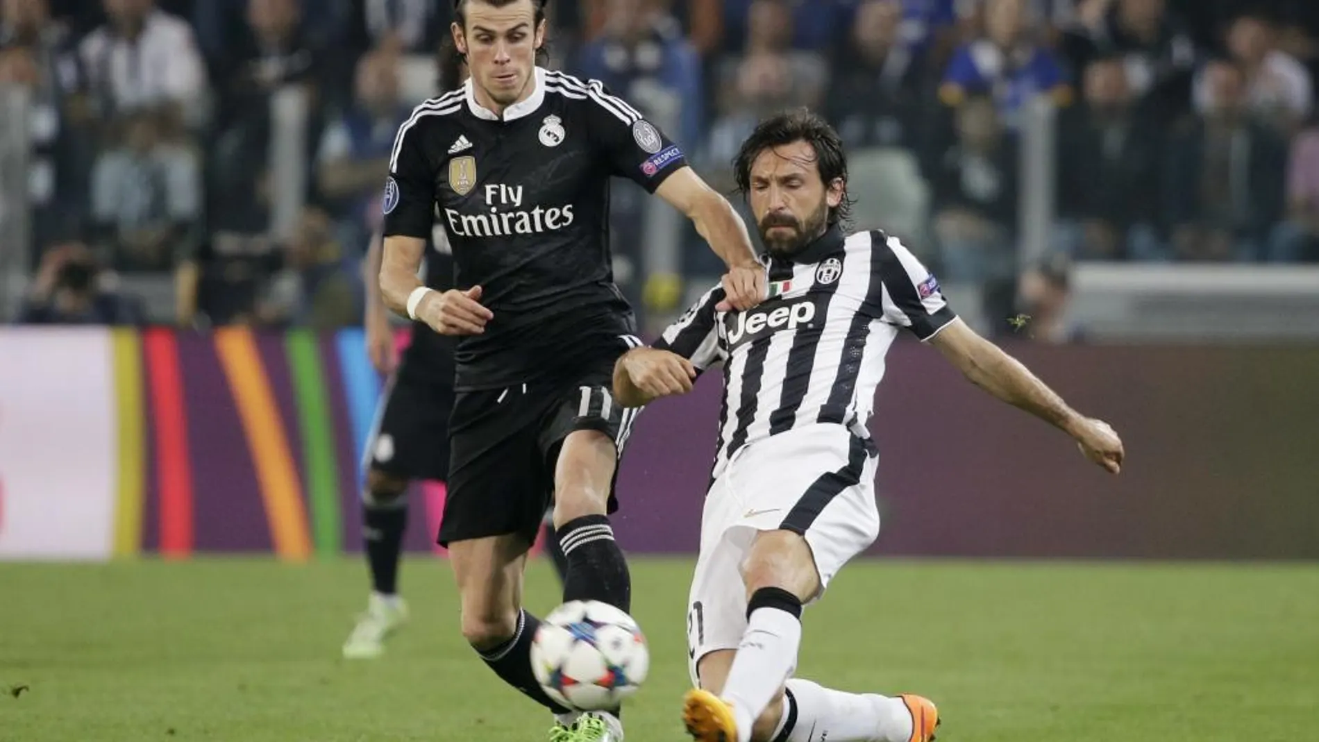 Pirlo araña un balón a Bale durante la semifinal de ayer en Turín