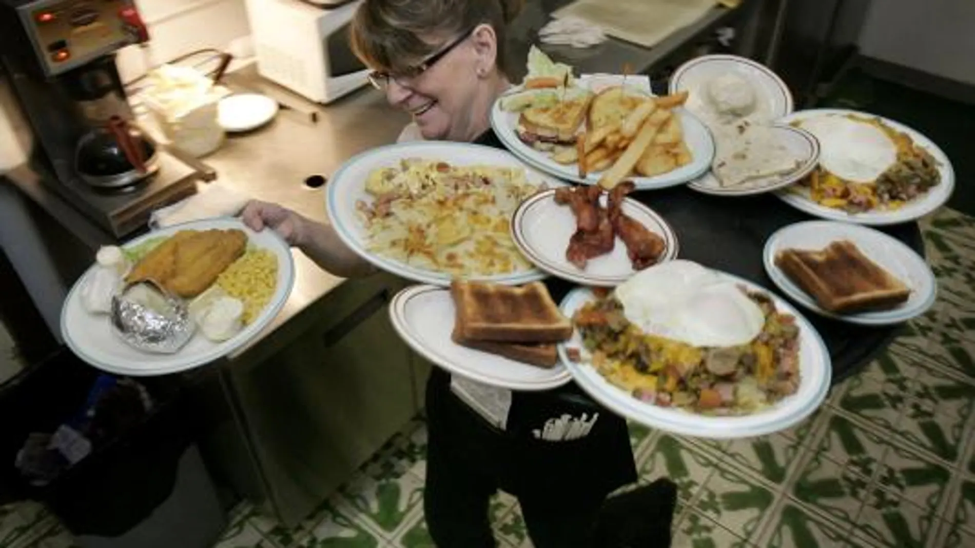 Una camarera con varios platos en las manos en una foto de archivo en Arizona