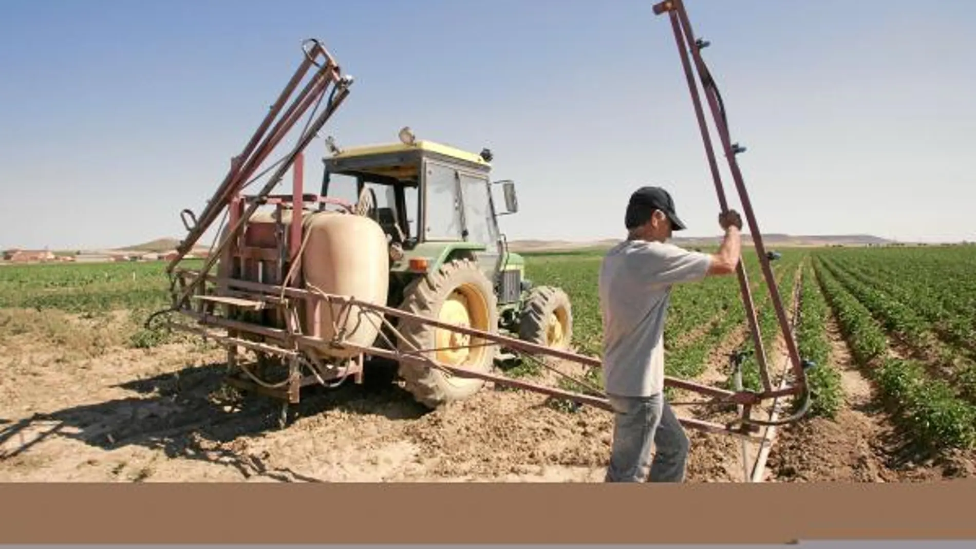 Un agricutor de Valladolid prepara su tractor para fumigar sus tierras sembradas de patatas