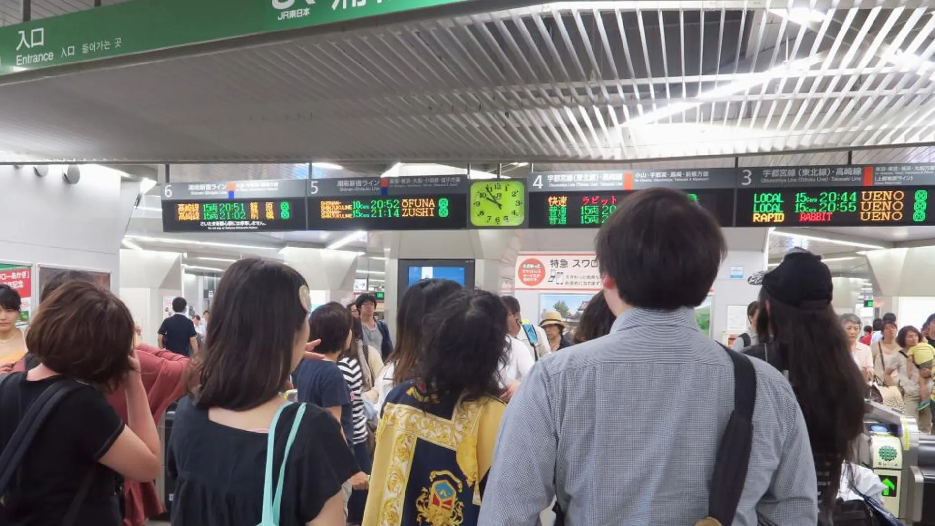 Viajeros miran el panel de horarios ferroviarios tras la alarma de terremoto que ha sacudido hoy Japón.