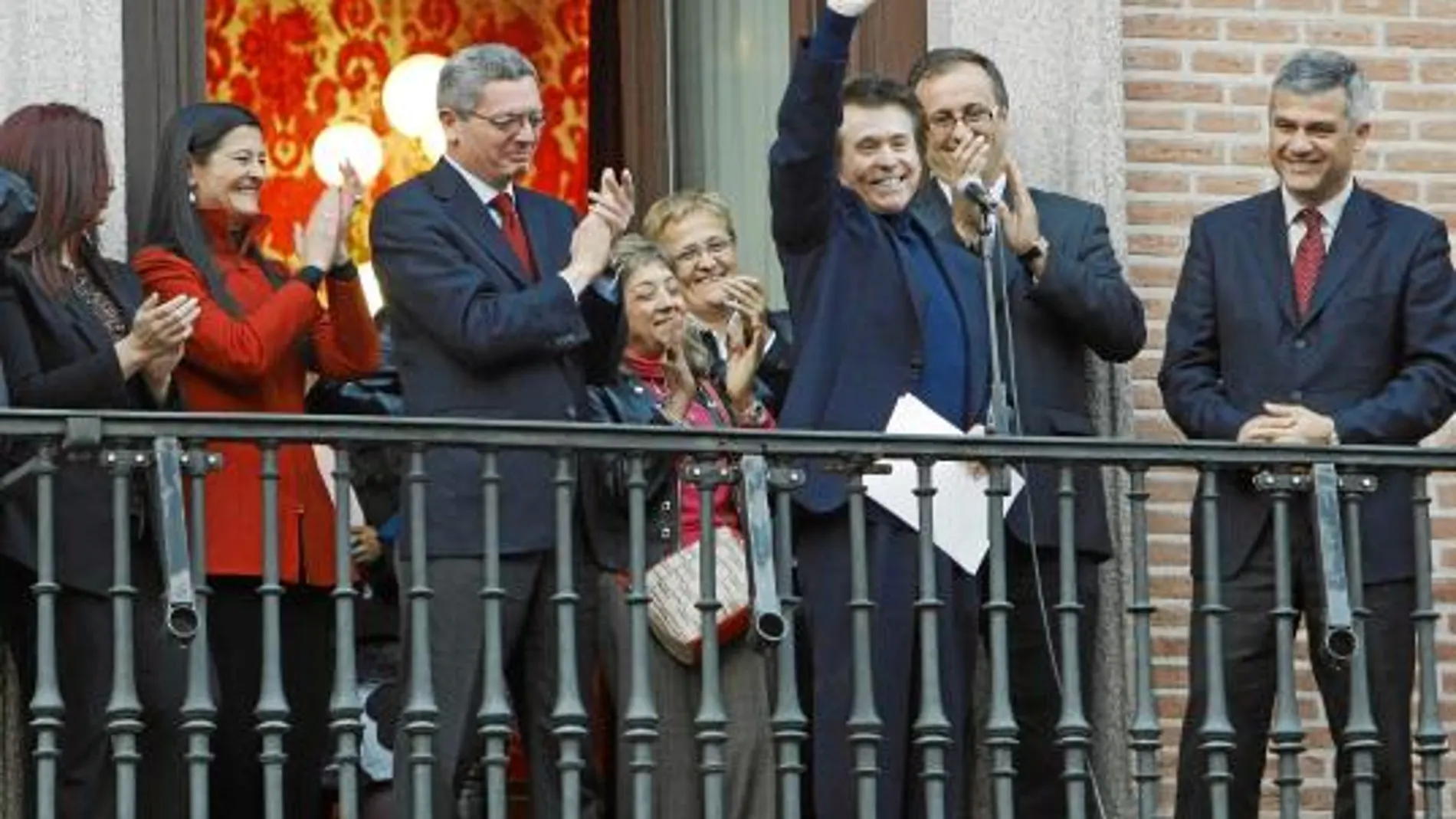 Raphael saluda al público que acudió a la Plaza de la Villa, ante la mirada de Gallardón