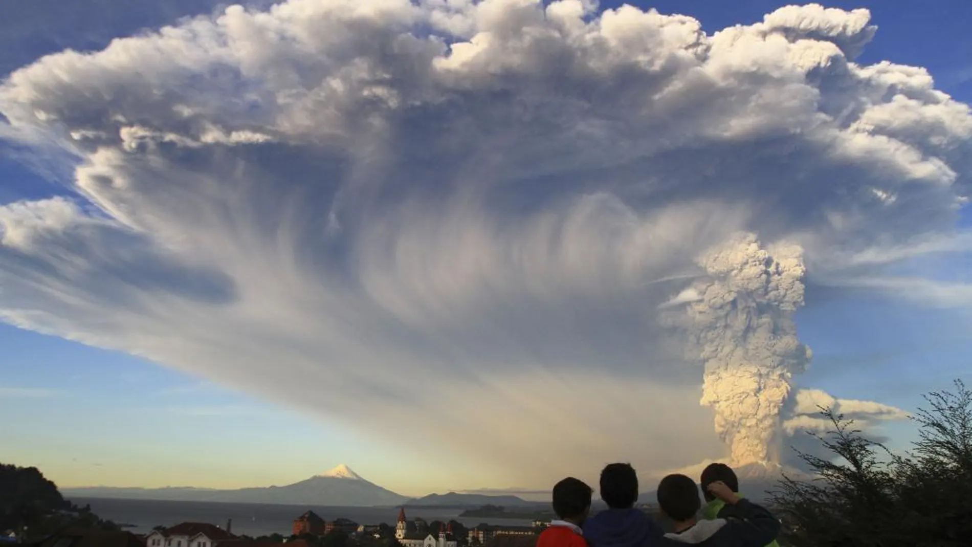 Varios niños observan la erupción del volcán desde Puerto Varas, Chile
