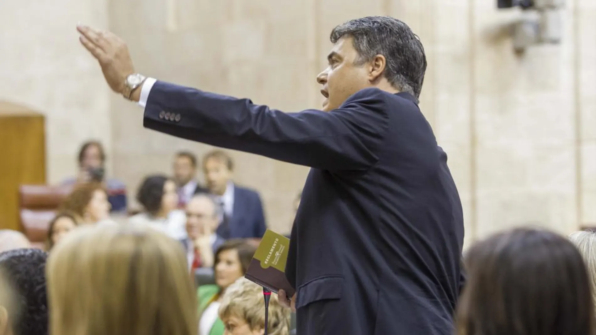 El diputado del PP Carlos Rojas, con el reglamento en la mano, muestra su disconformidad en la sesión constitutiva del Parlamento de Andalucía