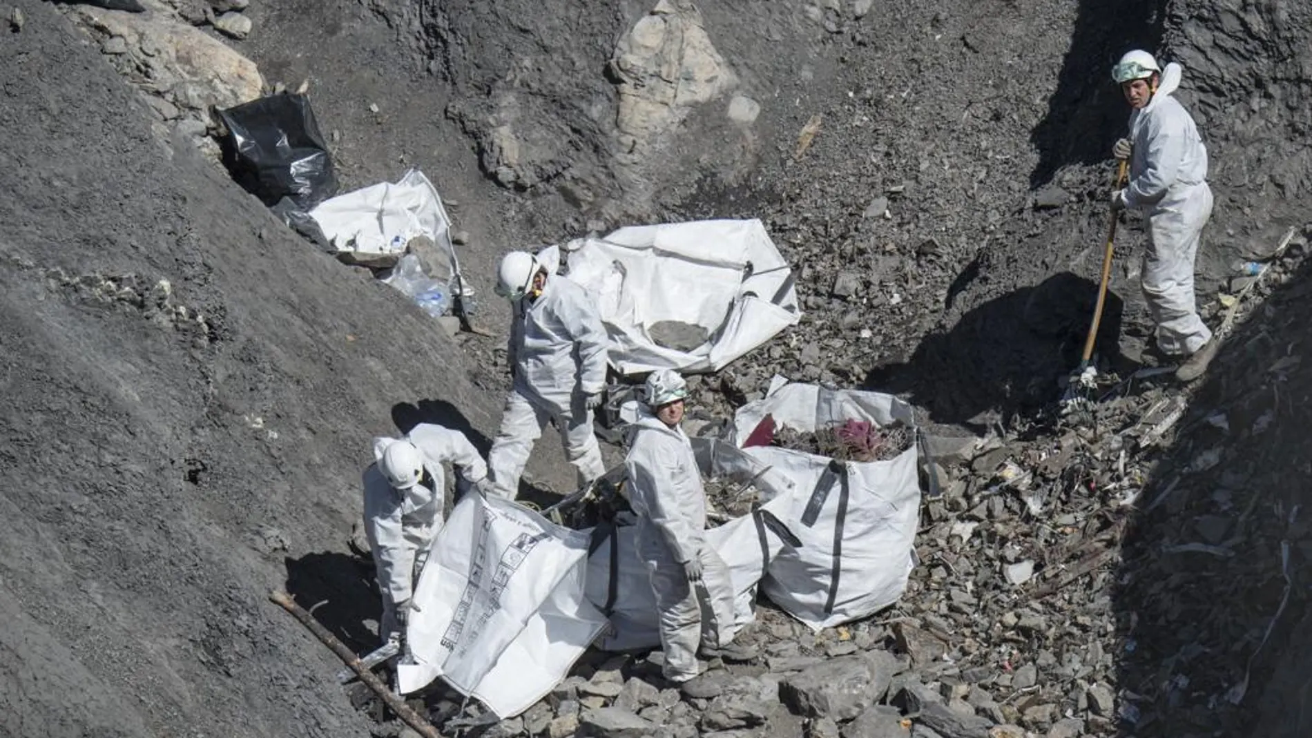 Los servicios de emergencias recogen los restos del avión y descontaminan la zona