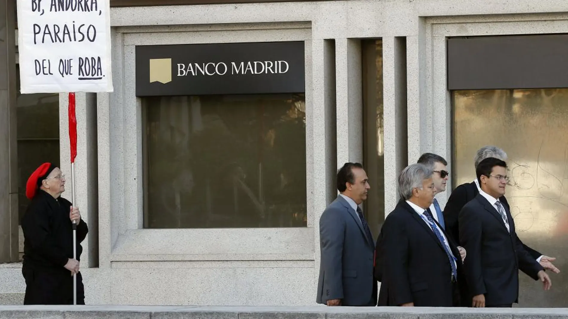 Un hombre protesta ante la sede del Banco de Madrid