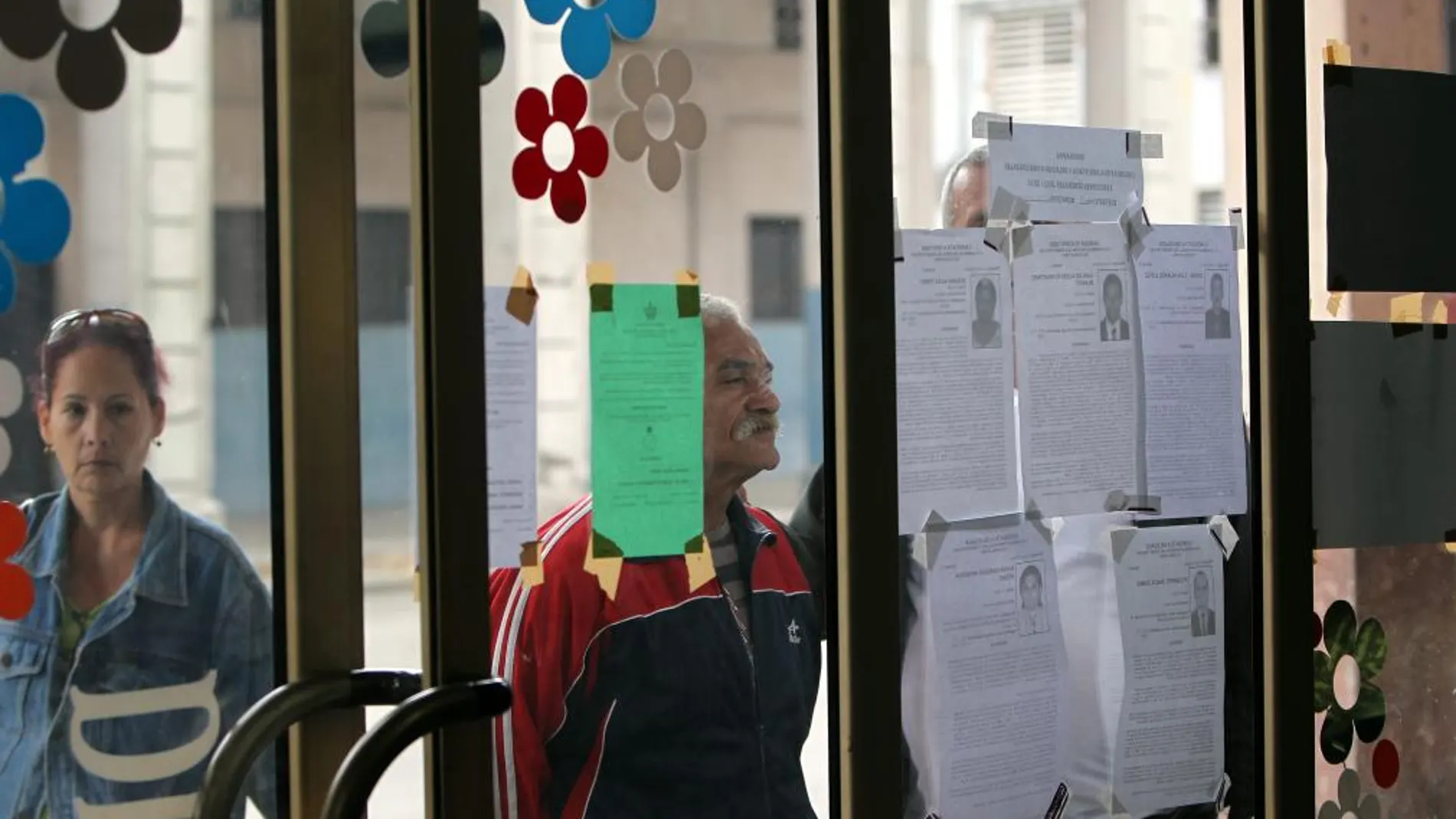 Un hombre lee las biografías de los candidatos