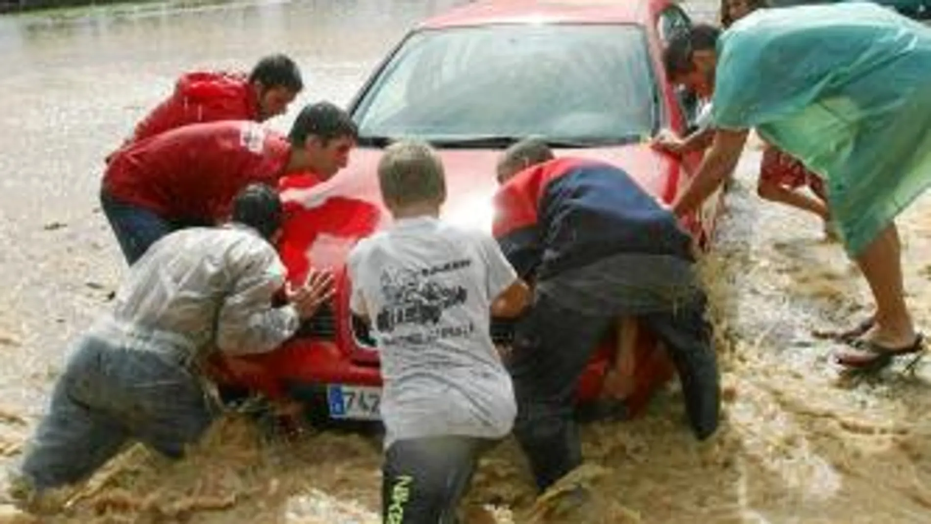 Unos jóvenes intentan sacar un coche de una riera en Tarragona