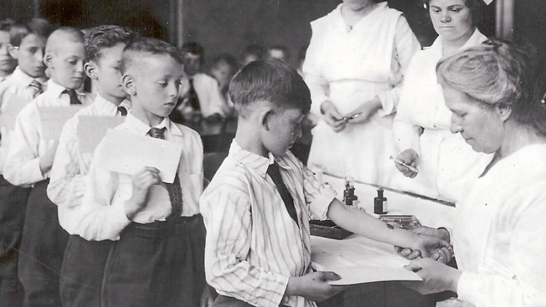 Una enfermera vacuna a una fila de niños en Nueva York en los años 20