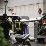 Agentes de la policía y del cuerpo de bomberos trasladan uno de los cuerpos de las fallecidas