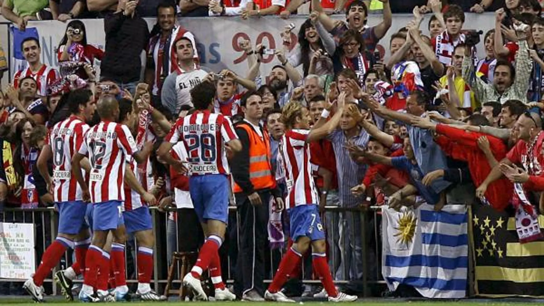 El delantero uruguayo del Atlético de Madrid, Diego Forlán (c), celebra su gol, primero de su equipo, con la afición, durante el partido