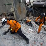 Los equipos de emergencia buscan víctimas entre los escombros de un edificio