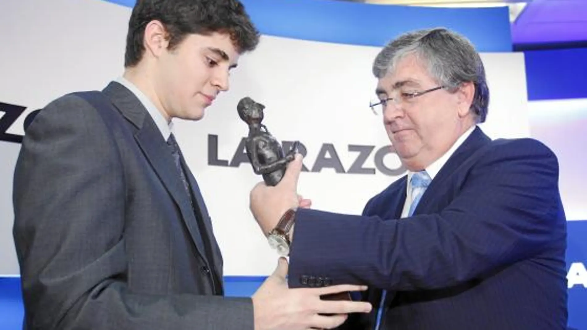 Francisco Javier Larrea, de la escuela de negocios ESIC, entrega la estatuilla a Carlos Lledó, con un 10 de nota media