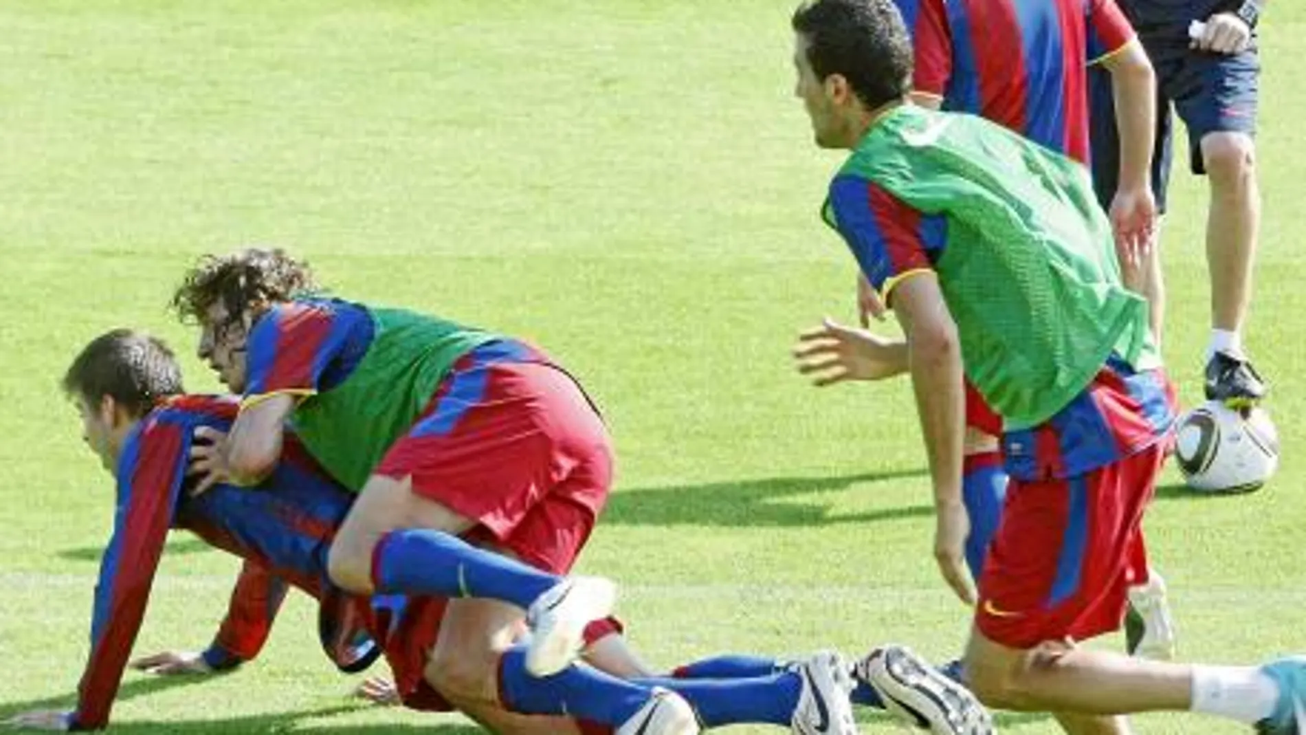 Piqué disputa la llegada a un balón con Puyol durante un entrenamiento del equipo de Guardiola