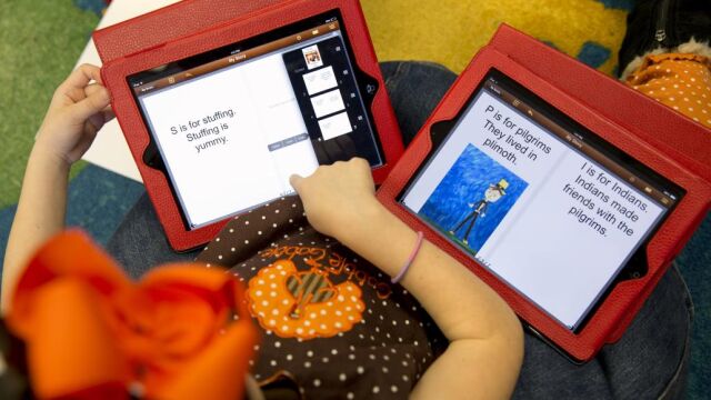 Una niña con dos tablets en clase