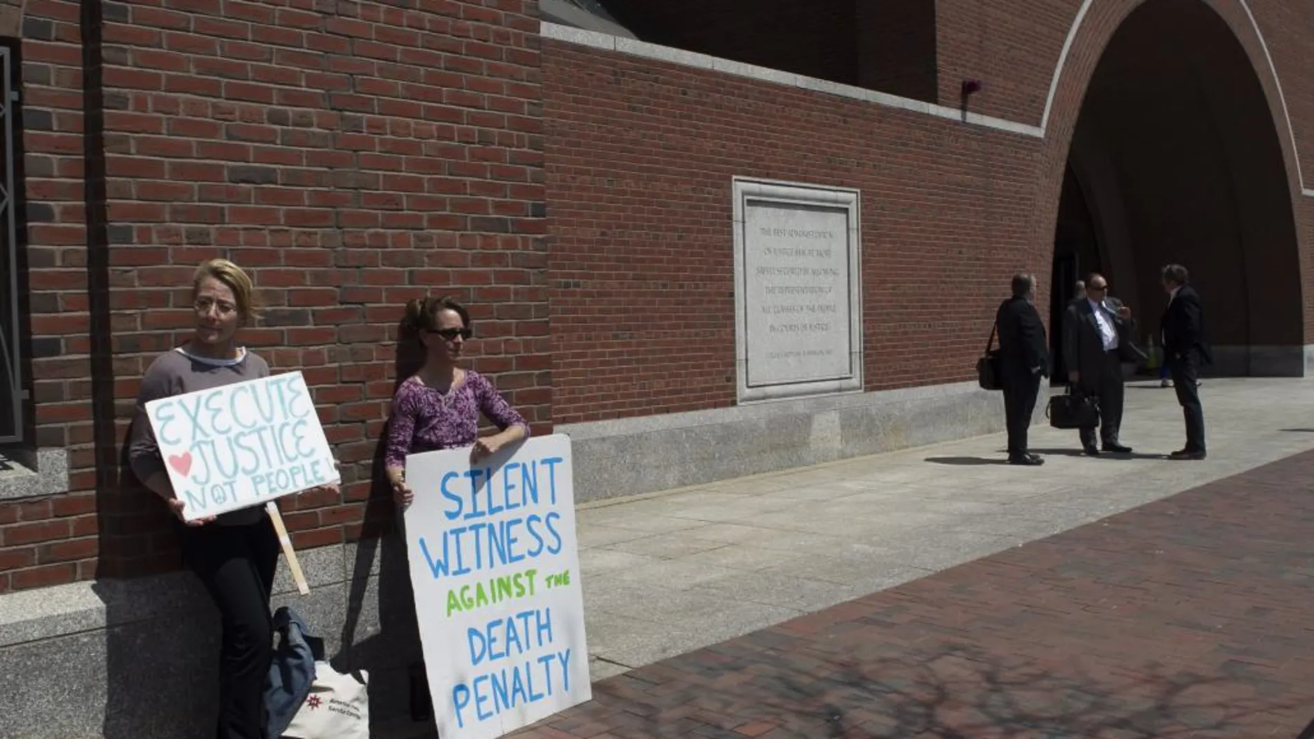 Dos manifestantes protestan contra la pena de muerte afuera de la audiencia en la que testificaron los familiares de Dzhokhar Tsarnaev el lunes 4 de mayo de 2015