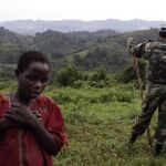 Una joven congolesa pasa junto a un soldado de los Cascos Azules de la ONU desplegados. Ap