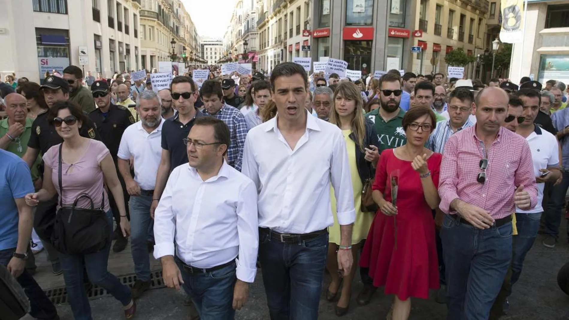 Pedro Sánchez durante el paseo que ha realizado por el centro histórico de Málaga, donde ha coincidido con una protesta que prejubilados de la empresa textil Hitemasa.