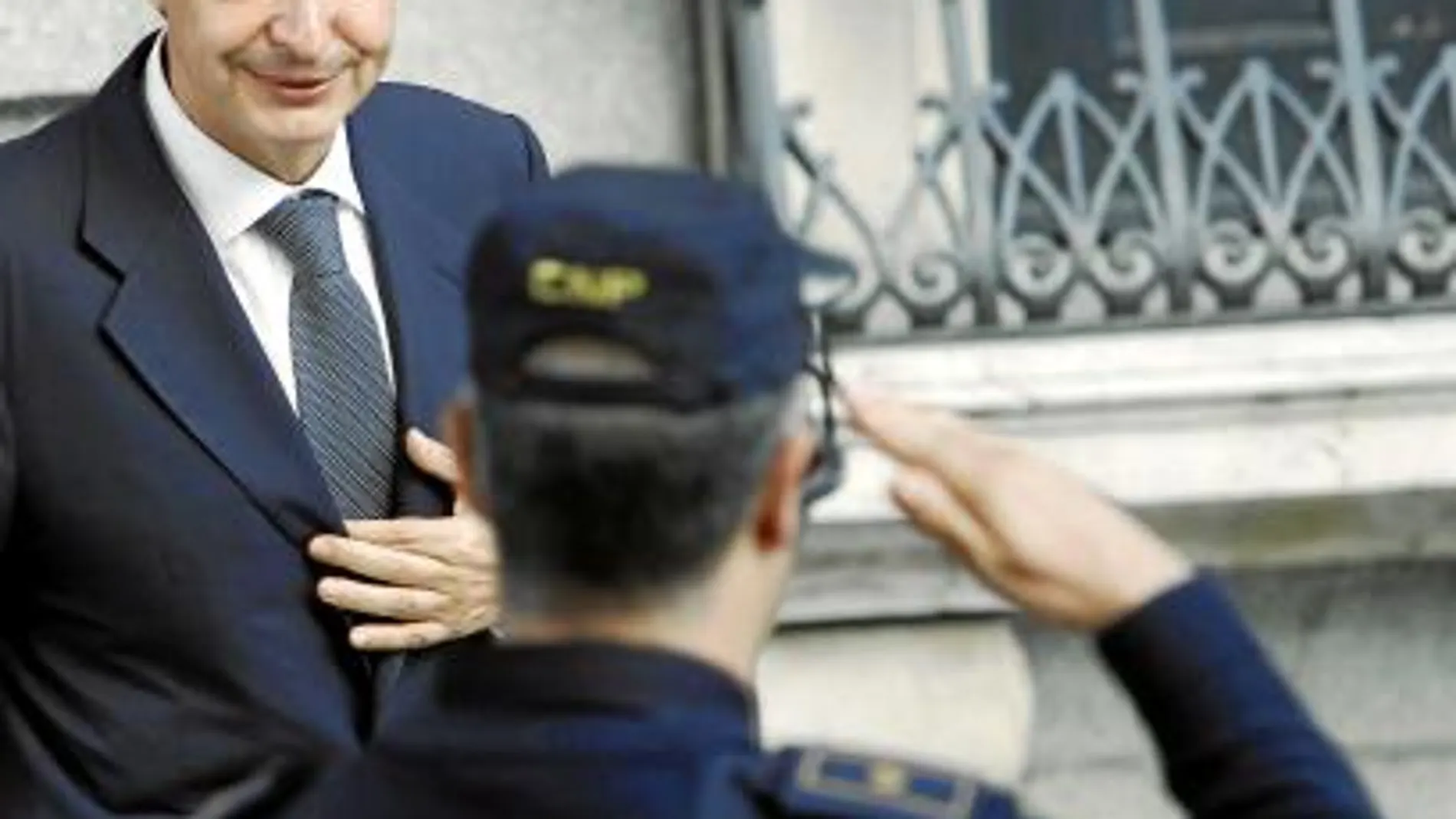 Un agente de la Policía saluda al presidente del Gobierno a la salida del Congreso de los diputados, donde ayer hubo un tenso Pleno