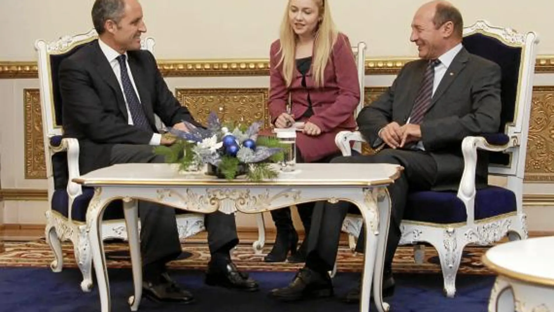 El presidente de la Generalitat, Francisco Camps y el de Rumanía, Traian Basescu departen con la ayuda de una intérprete
