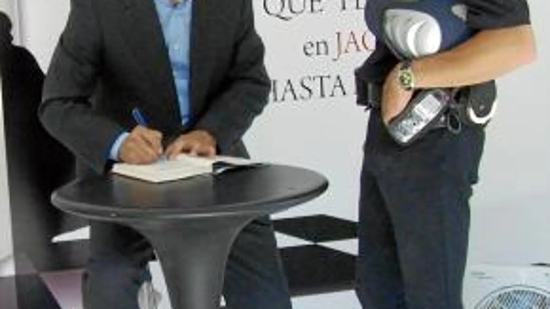 Pérez Reverte firma un ejemplar a un policía nacional