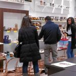 Unos jóvenes observan los productos que ofrece la nueva tienda navideña