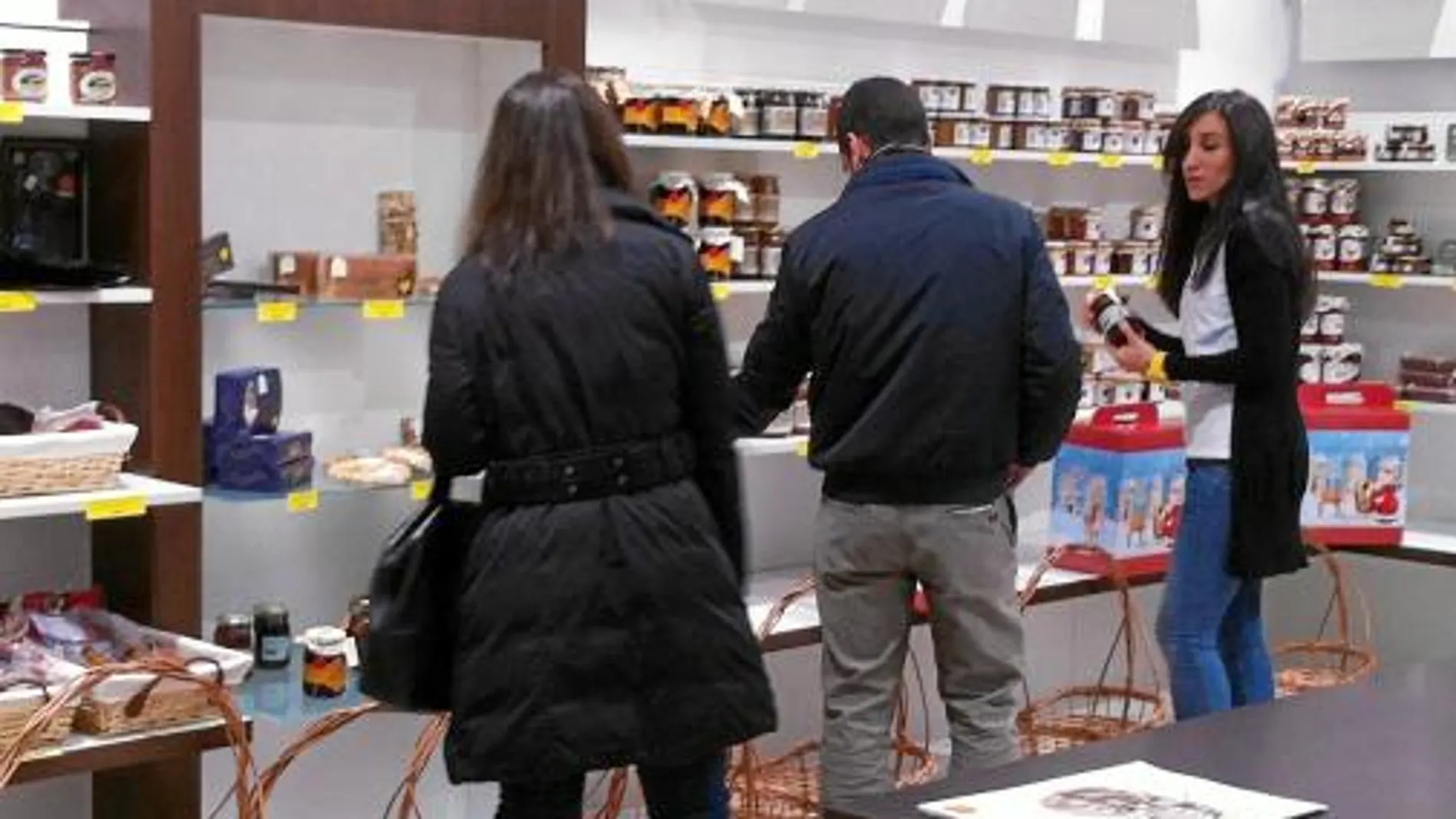 Unos jóvenes observan los productos que ofrece la nueva tienda navideña