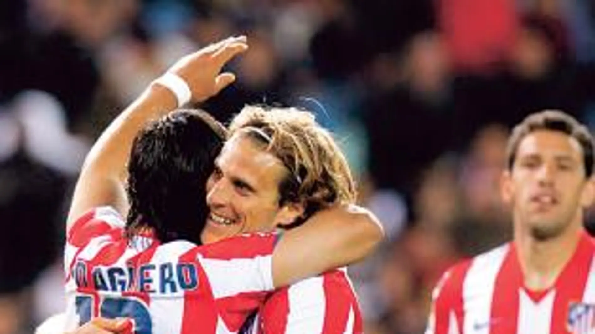 FORLÁN Y AGÜERO se abrazan tras uno de los goles del Atlético