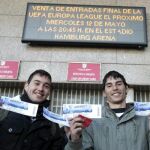Dos aficionados del Atlético de Madrid muestran las entradas que acaban de comprar en las taquillas del estadio Vicente Calderón para presenciar la final de la Liga Europa