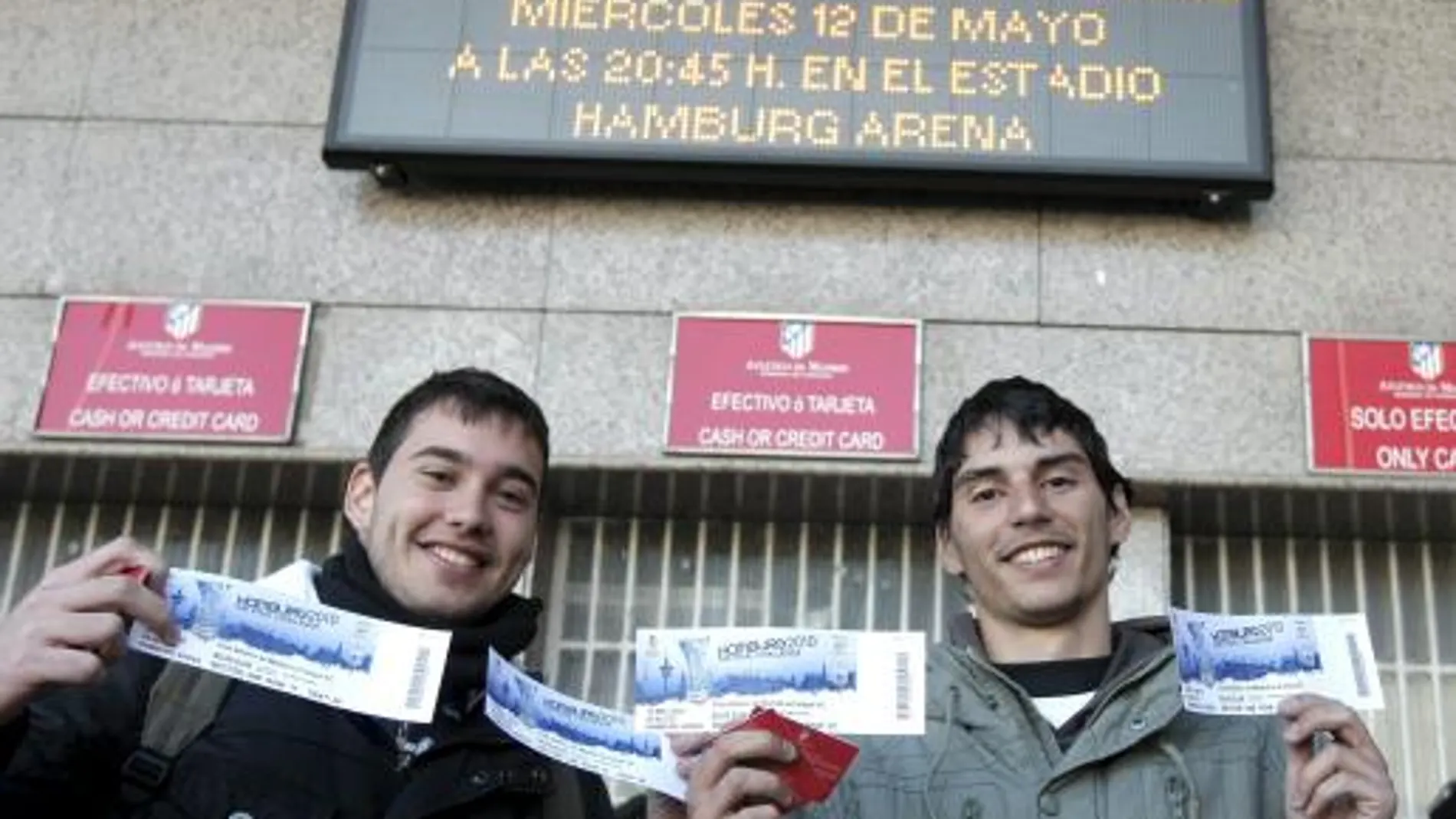 Dos aficionados del Atlético de Madrid muestran las entradas que acaban de comprar en las taquillas del estadio Vicente Calderón para presenciar la final de la Liga Europa