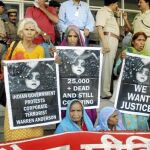 Supervivientes de la tragedia muestran pancartas exigiendo justicia en las puertas del juzgado, en Bhopal, India