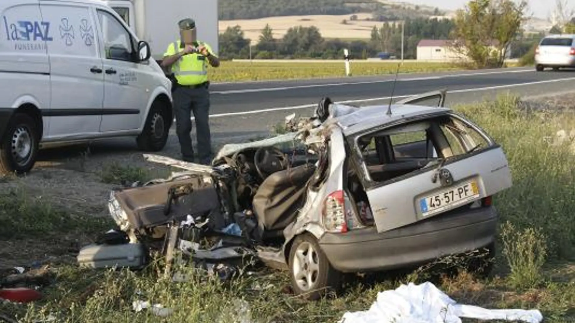 Un agente de la Guardia Civil inspecciona el Opel Corsa con matrícula portuguesa que protagonizó el siniestro