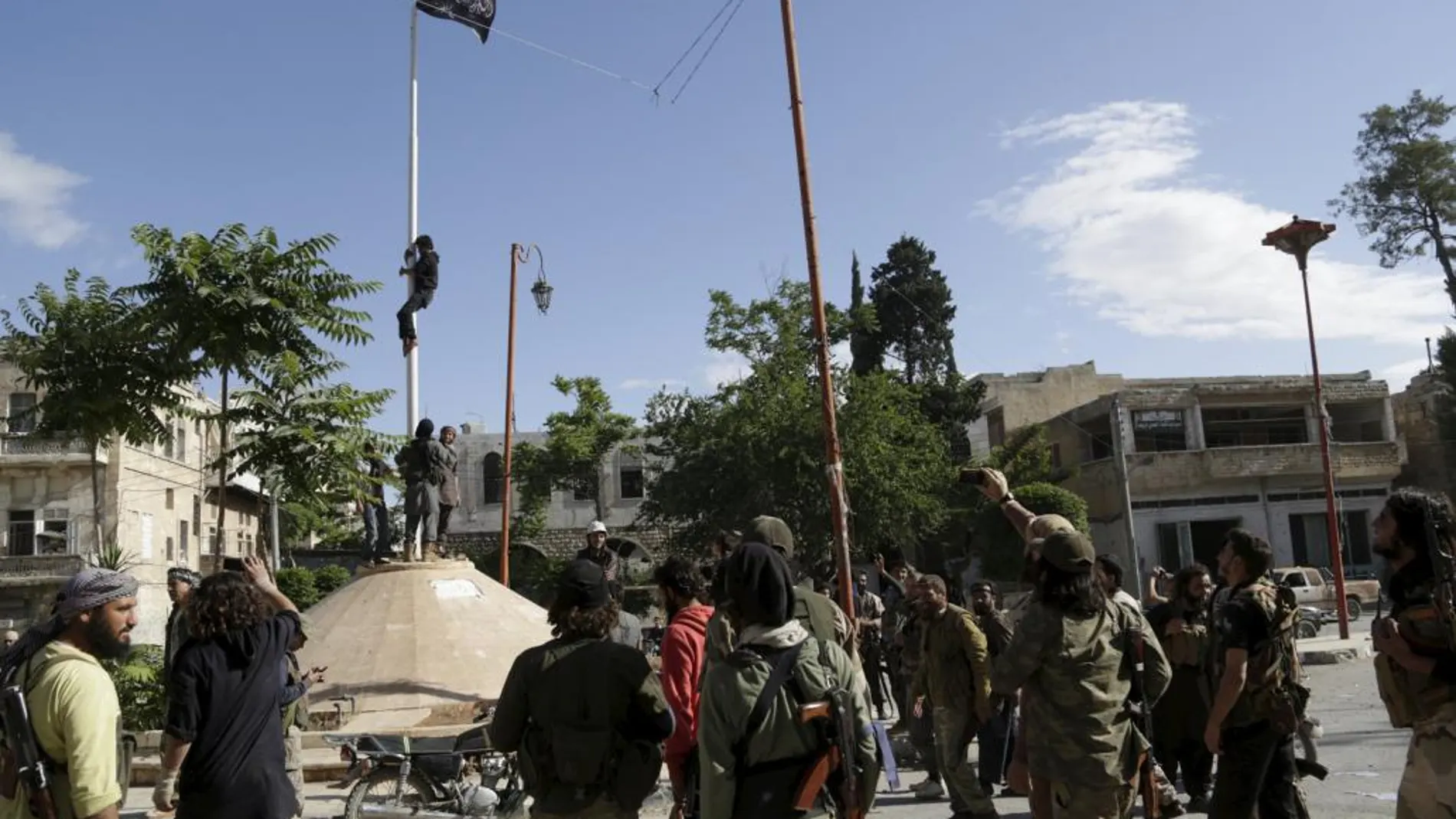 Miembros del Frente al Nusra tras izar una bandera del Estado Islámico en Ariha