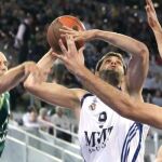 El pívot del Real Madrid, Felipe Reyes (c) intenta un lanzamiento ante el alero del Unicaja Carlos Jiménez (i) durante el partido correspondiente a la segunda jornada de Euroliga de baloncesto