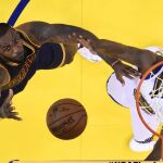 LeBron James (i) de Cavaliers ante Draymond Green (d) de Warriors, durante el primer el juego de la final de la NBA en el Oracle Arena de Oakland,