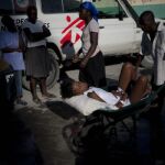 Un hombre lleva a una mujer con síntomas de cólera al hospital en Puerto Príncipe (Haití)