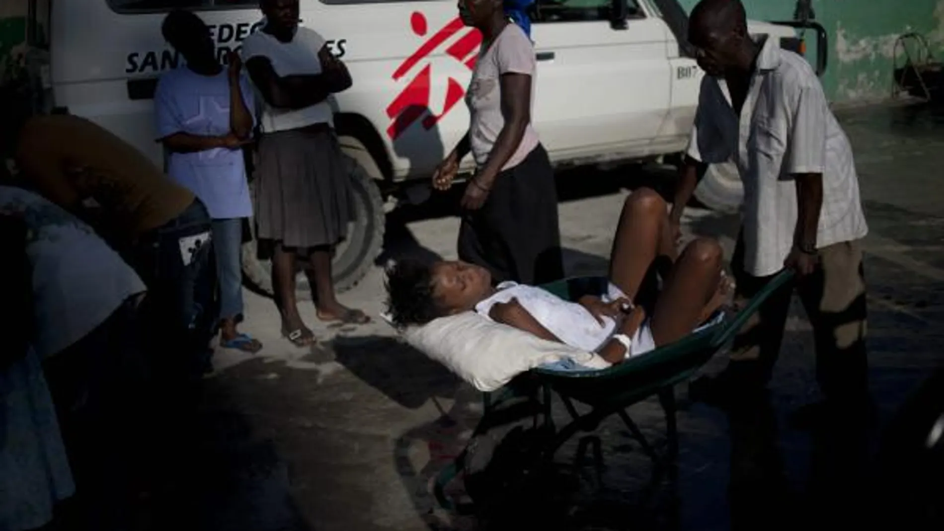 Un hombre lleva a una mujer con síntomas de cólera al hospital en Puerto Príncipe (Haití)