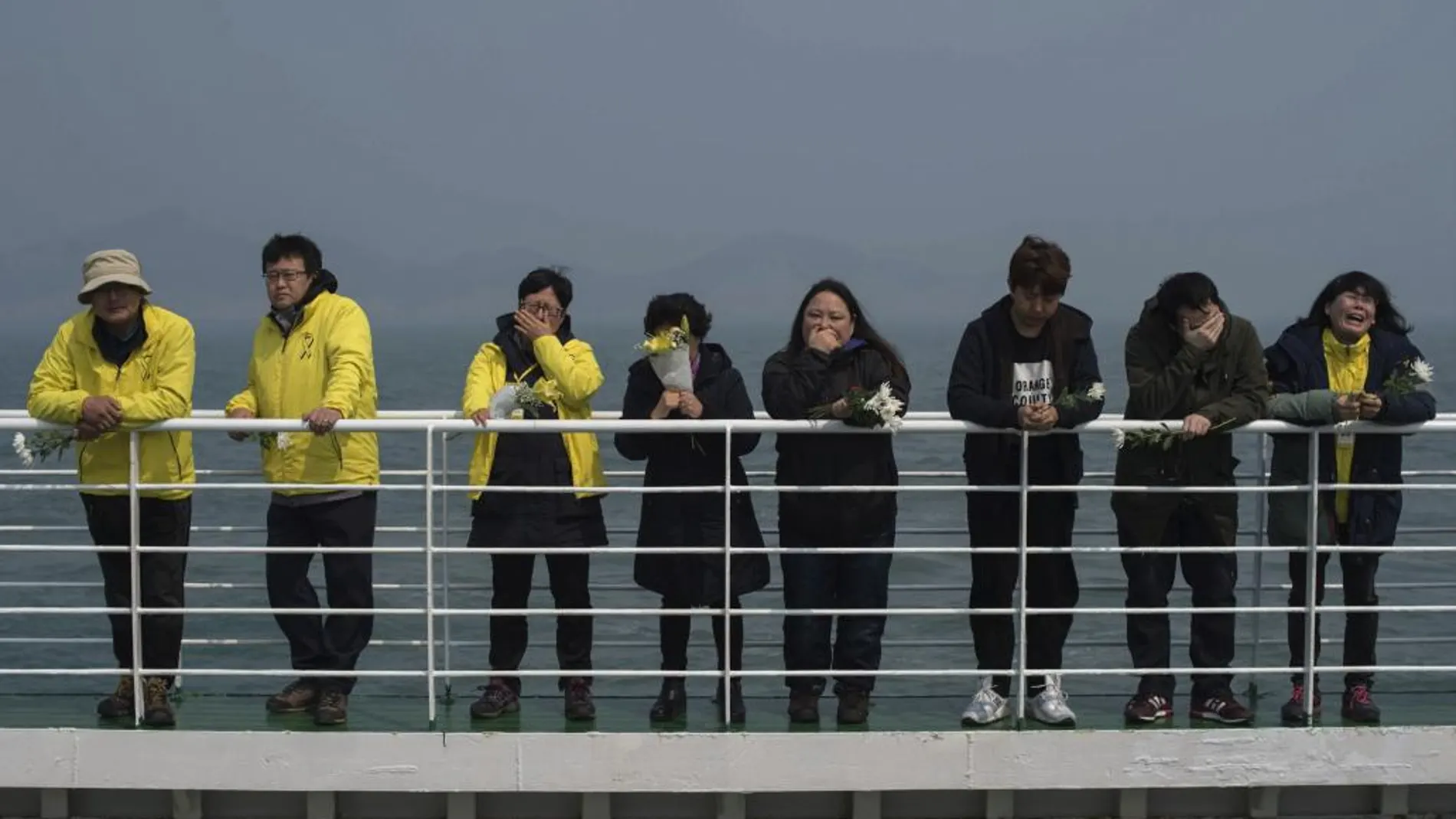 Familiares de víctimas del naufragio rinden un homenaje a los 304 fallecidos desde la cubierta de un barco cerca de la costa de la isla Jindo