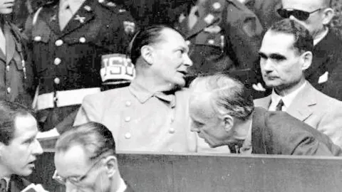 Goering habla con Joachin von Ribbentrop durante el proceso de Nurembert; a su lado está Rudolf Hess