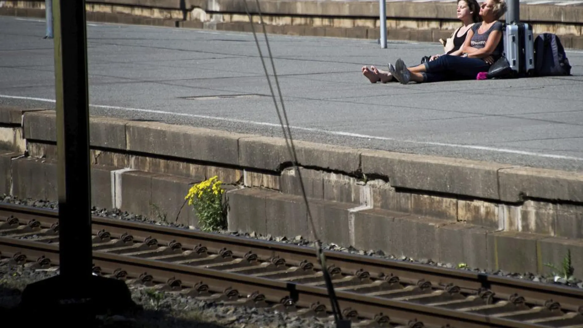Dos turistas holandesas esperan la llegada del tren en la estación central de Hannover, Alemania