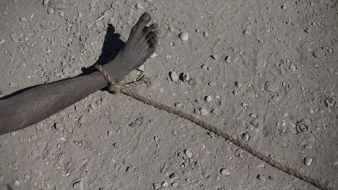 Detalle del cadáver de un hombre que yace desnudo