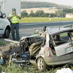 Un agente de la guardia civil toma imágenes del vehículo con matrícula portuguesa que colisionó con el trailer