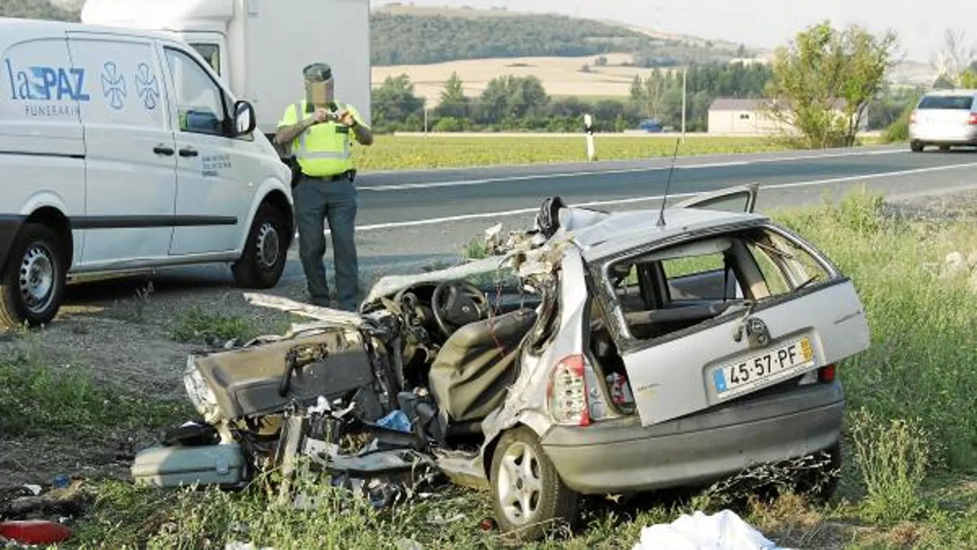 Un agente de la guardia civil toma imágenes del vehículo con matrícula portuguesa que colisionó con el trailer