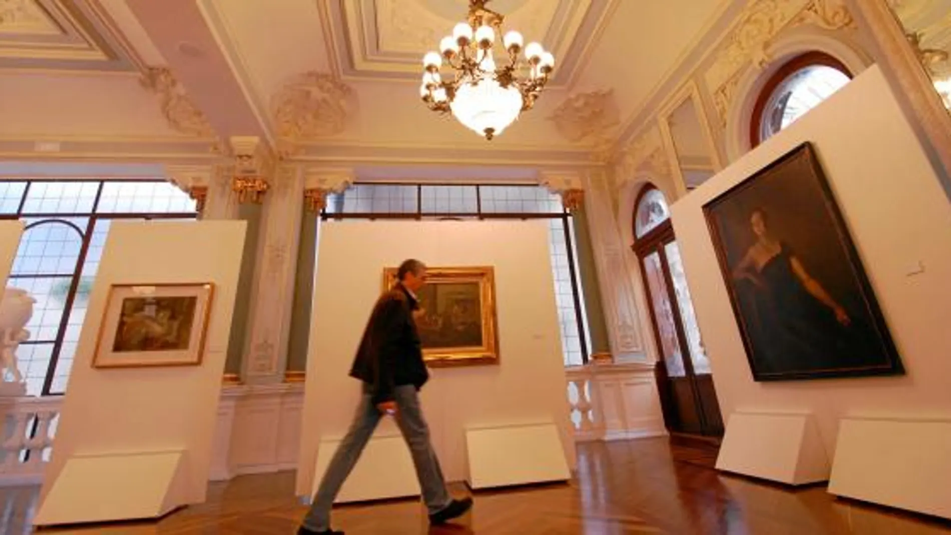 Un visitante pasea por la sala del Casino de Murcia donde se exhiben las obras del pintor murciano, Ramón Gaya