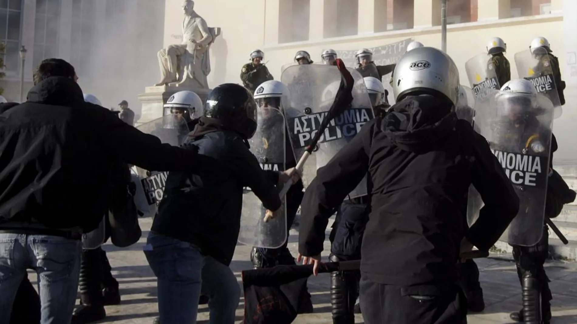 Varios anarquistas se enfrentan a los antidisturbios durante una protesta ayer en la Universidad de Atenas