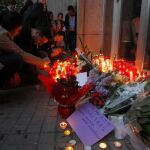 Varias personas depositan flores y velas a las puertas del Instituto de Educación Secundaria Joan Fuster en recuerdo del docente asesinado hoy por un alumno de 13 años.