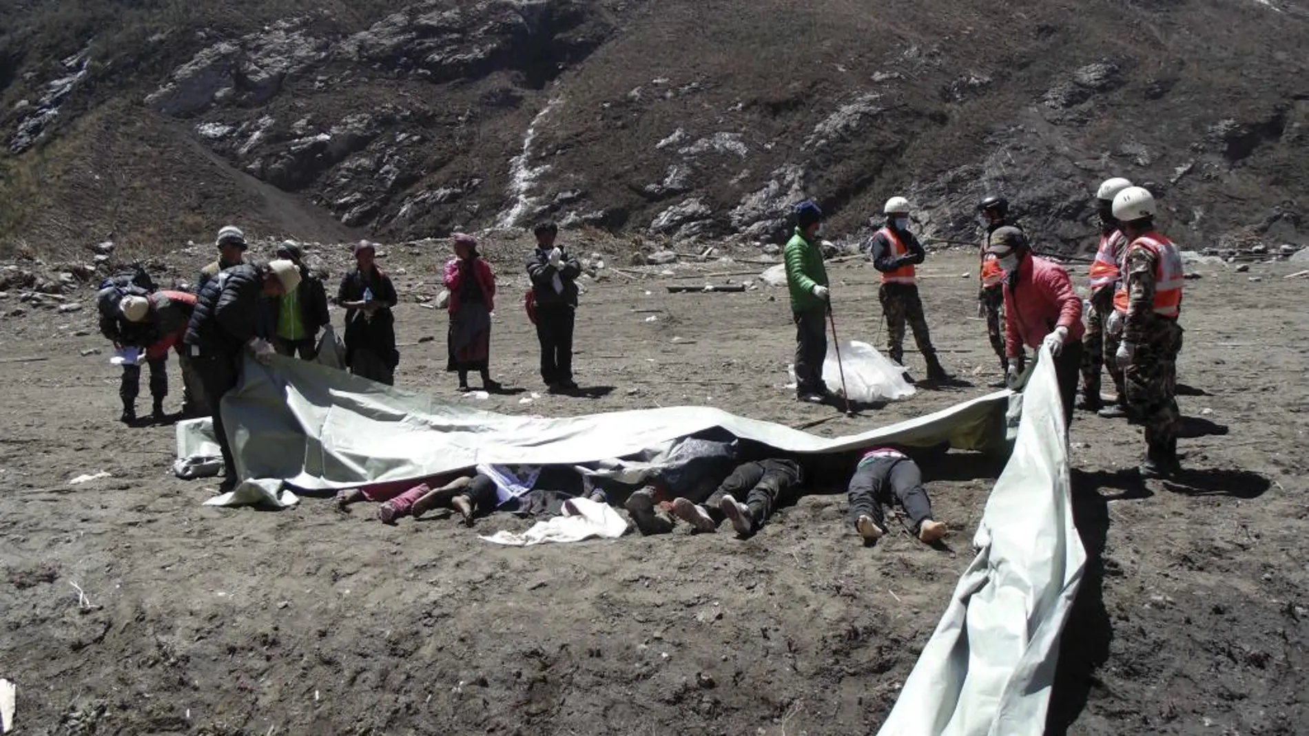 La policía nepalí en la que se muestra a varios miembros de un equipo de rescate cubriendo los restos mortales de algunas de las víctimas del terremoto