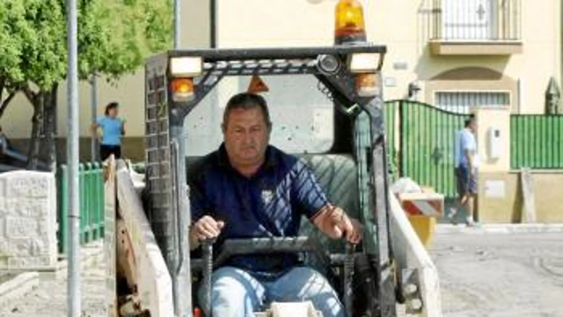 Un técnico municipal retira lodo con una excavadora
