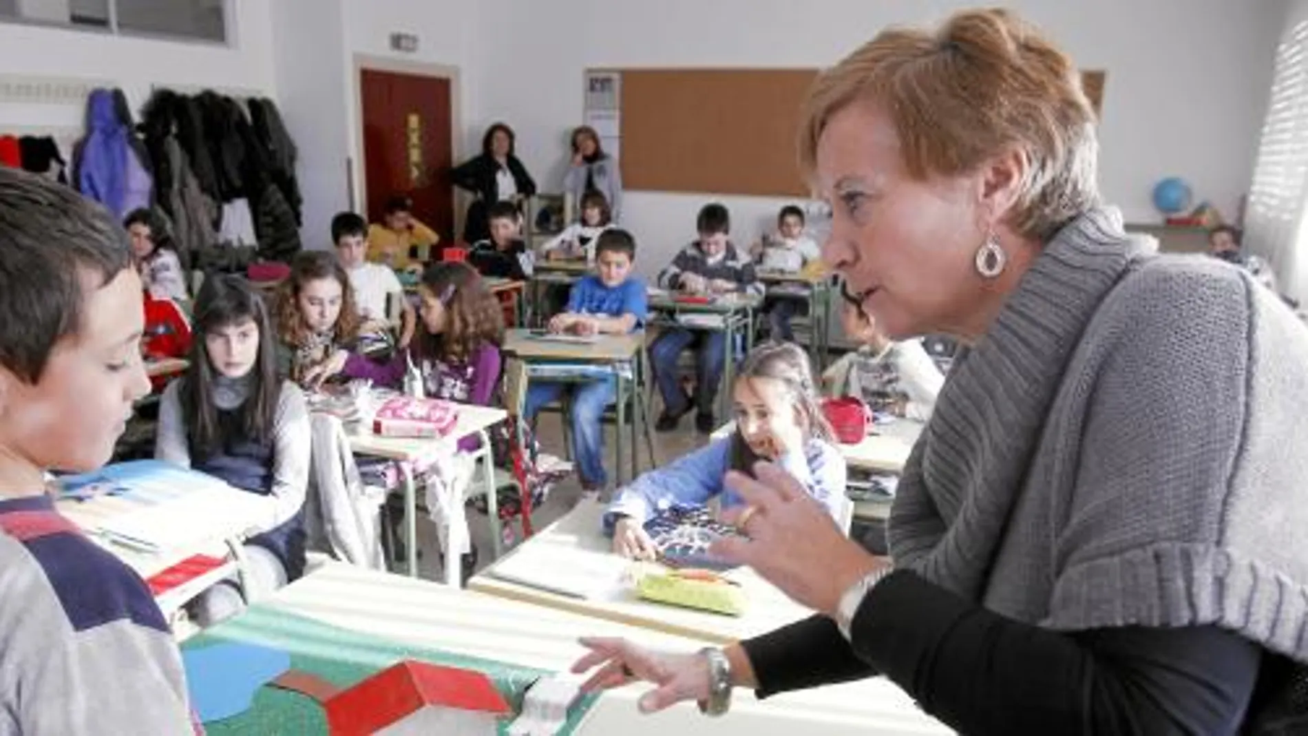 La profesora Rosa habla en inglés con un alumno en el colegio «Los doce linajes»