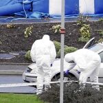 Dos forenses examinan el lugar del último atentado en Belfast